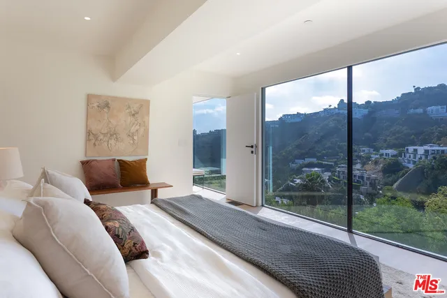 a bedroom with a large bed and a balcony view