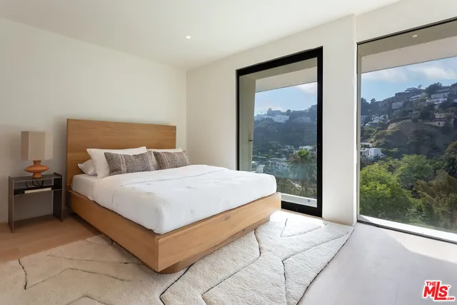 a large bed sitting in a bedroom next to a window