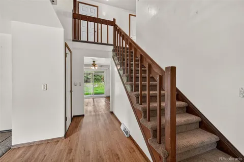 a view of staircase with wooden floor and white walls