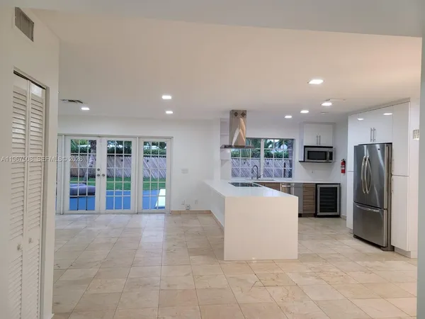 a kitchen with a refrigerator and a counter top space