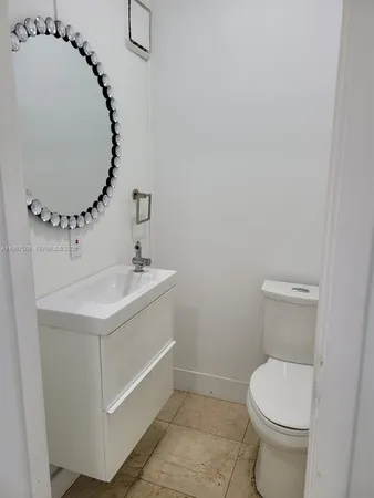 a bathroom with a sink mirror vanity and toilet