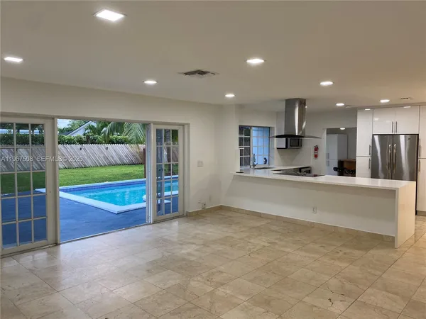 a view of kitchen with stainless steel appliances granite countertop a barbecue grill and cabinets