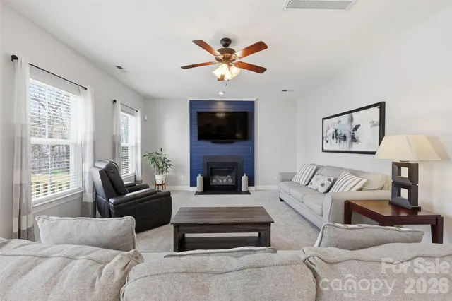 a living room with furniture a fireplace and a flat screen tv