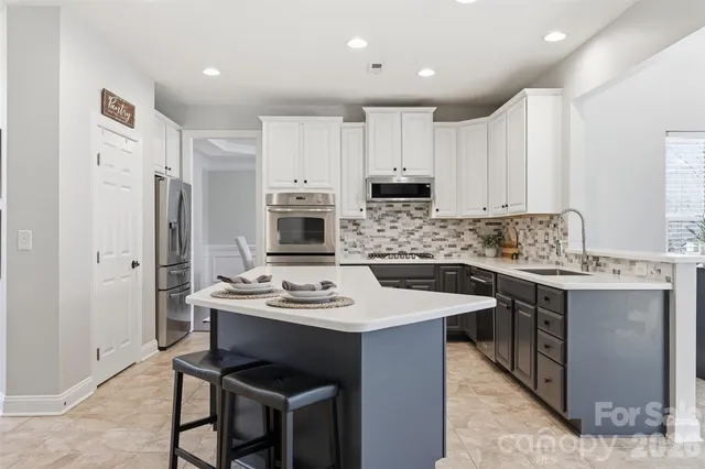 a large kitchen with kitchen island a sink table and chairs