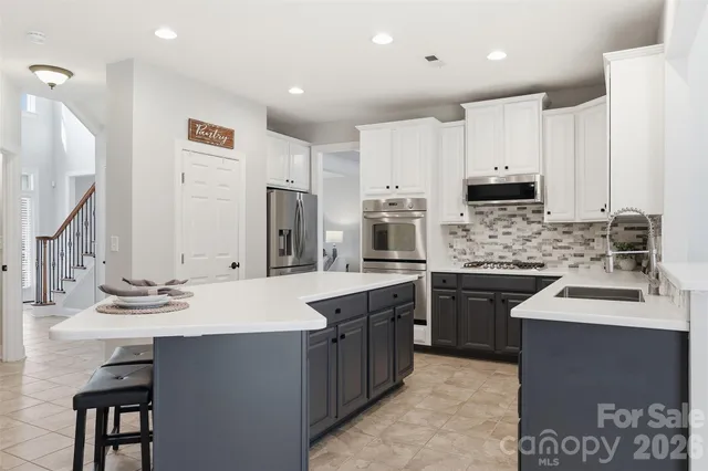 a kitchen with stainless steel appliances granite countertop a stove microwave and cabinets