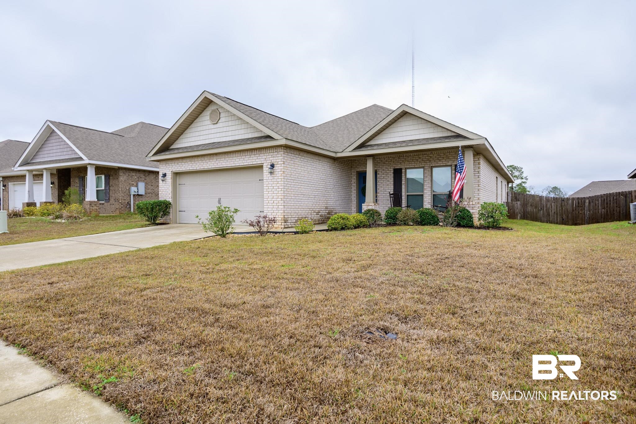 31751 Kestrel Loop Daphne, AL 36527 - Photo 3 of 21 Ranch-style home featuring a garage, driveway, brick siding, covered porch, and a shingled roof