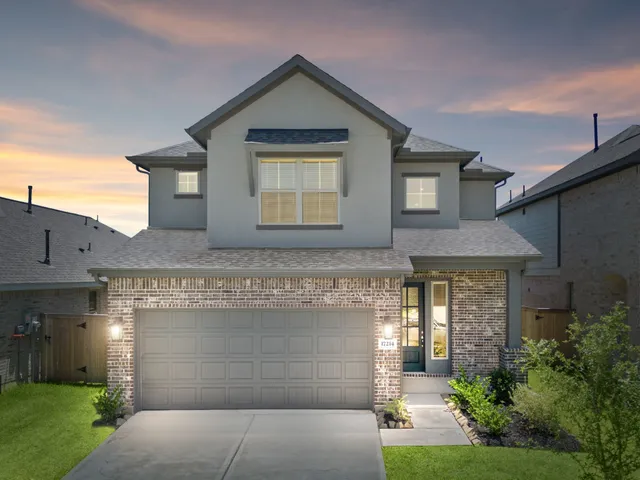 a front view of a house with a garden and garage