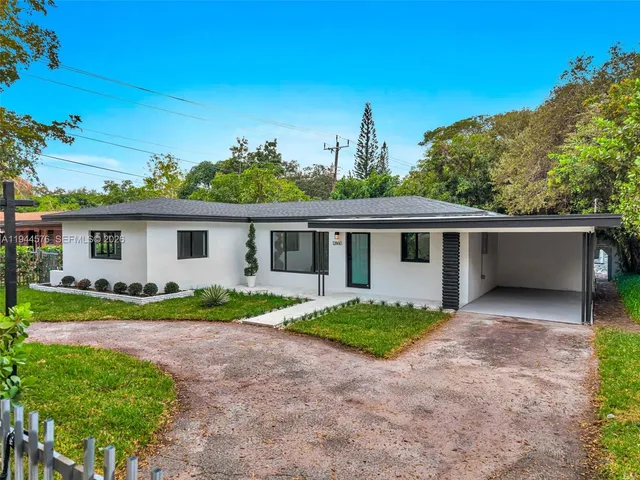 a view of house with a big yard and potted plants