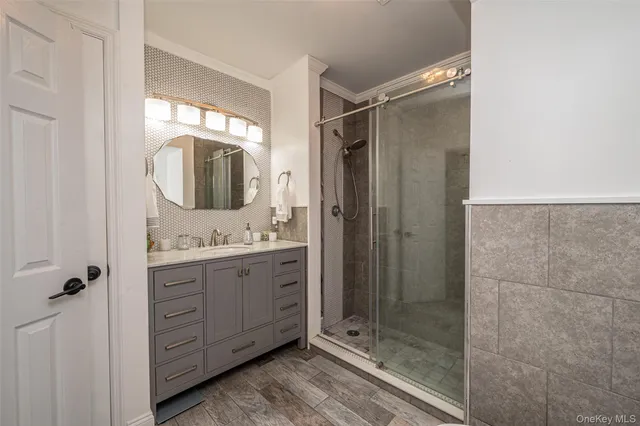 a bathroom with a granite countertop sink mirror and shower
