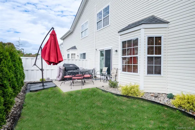 a view of house with backyard and sitting area