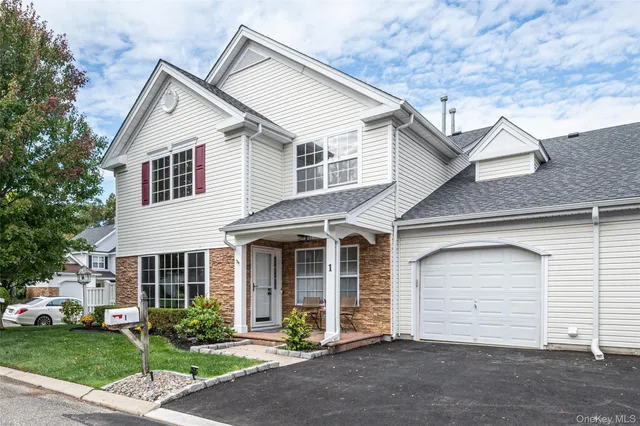 a view of a house with a yard and large tree
