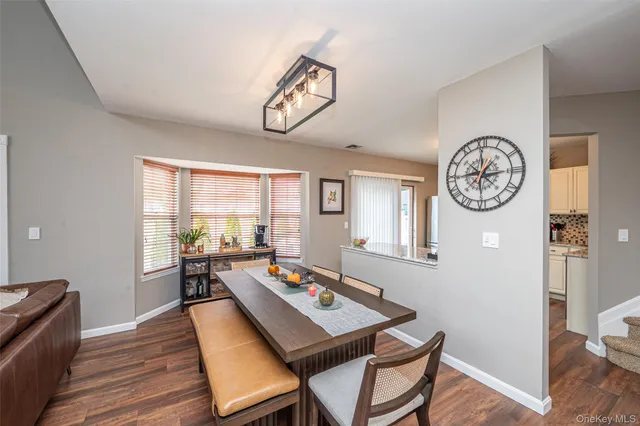 a view of a dining room with furniture a chandelier and wooden floor