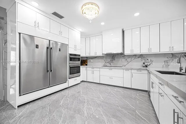 a kitchen with white cabinets stainless steel appliances and a window