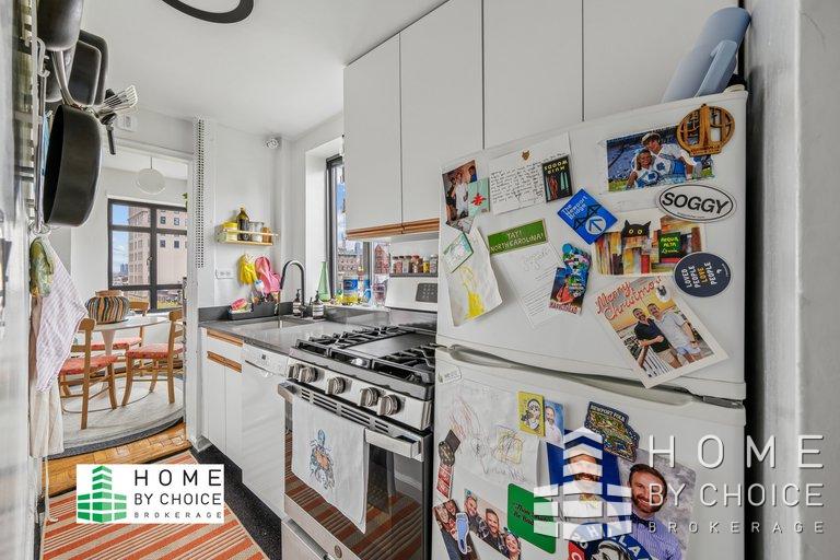 100 Remsen Street, Unit 8A Brooklyn, NY 11201 - Photo 5 of 14 a kitchen with stainless steel appliances and a table