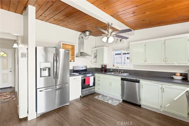 a kitchen with stainless steel appliances a sink a stove a refrigerator and cabinets