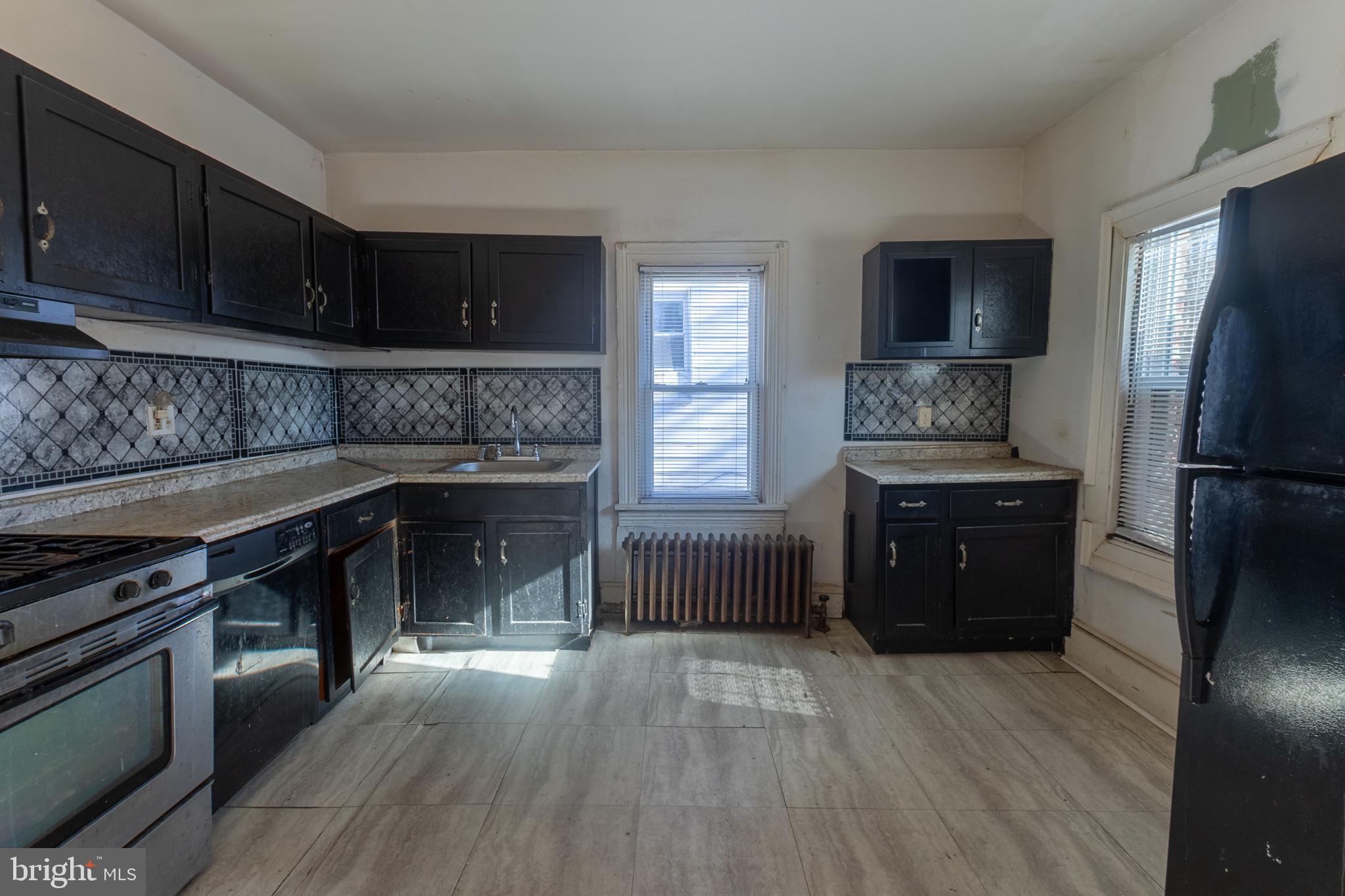 5911 Crown Street Capitol Heights, MD 20743 - Photo 8 of 28 a kitchen with a refrigerator stove and wooden cabinets