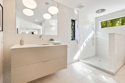 a en suite bathroom with a sink mirror and a shower