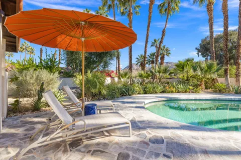 a view of a swimming pool with a patio and a yard