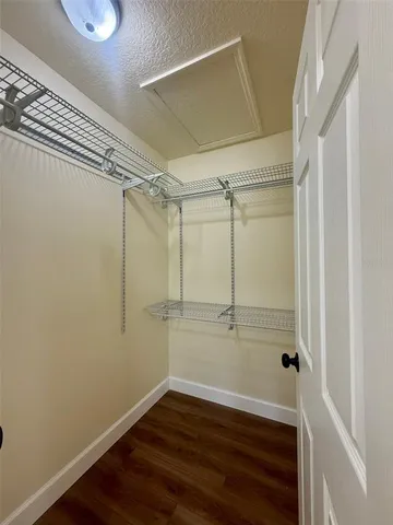 a view of a room with wooden floor and small window