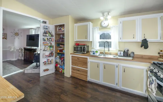 a kitchen with cabinets and wooden floor
