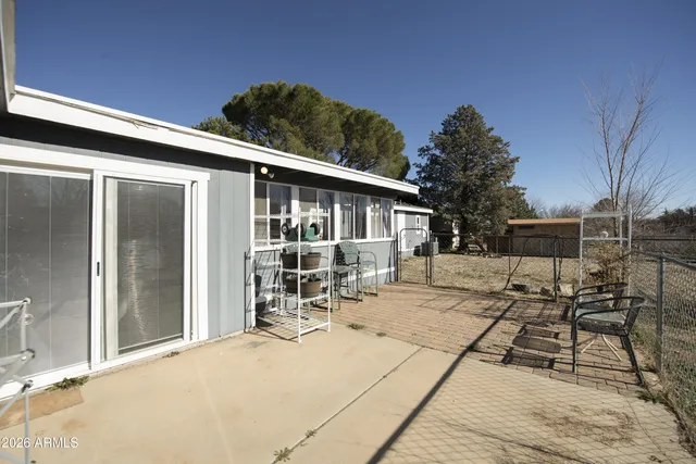 a patio with table and chairs and potted plants
