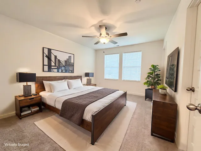 a spacious bedroom with a bed and a flat screen tv