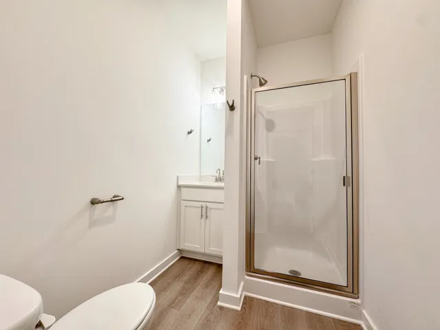 a bathroom with a granite countertop toilet a sink and shower