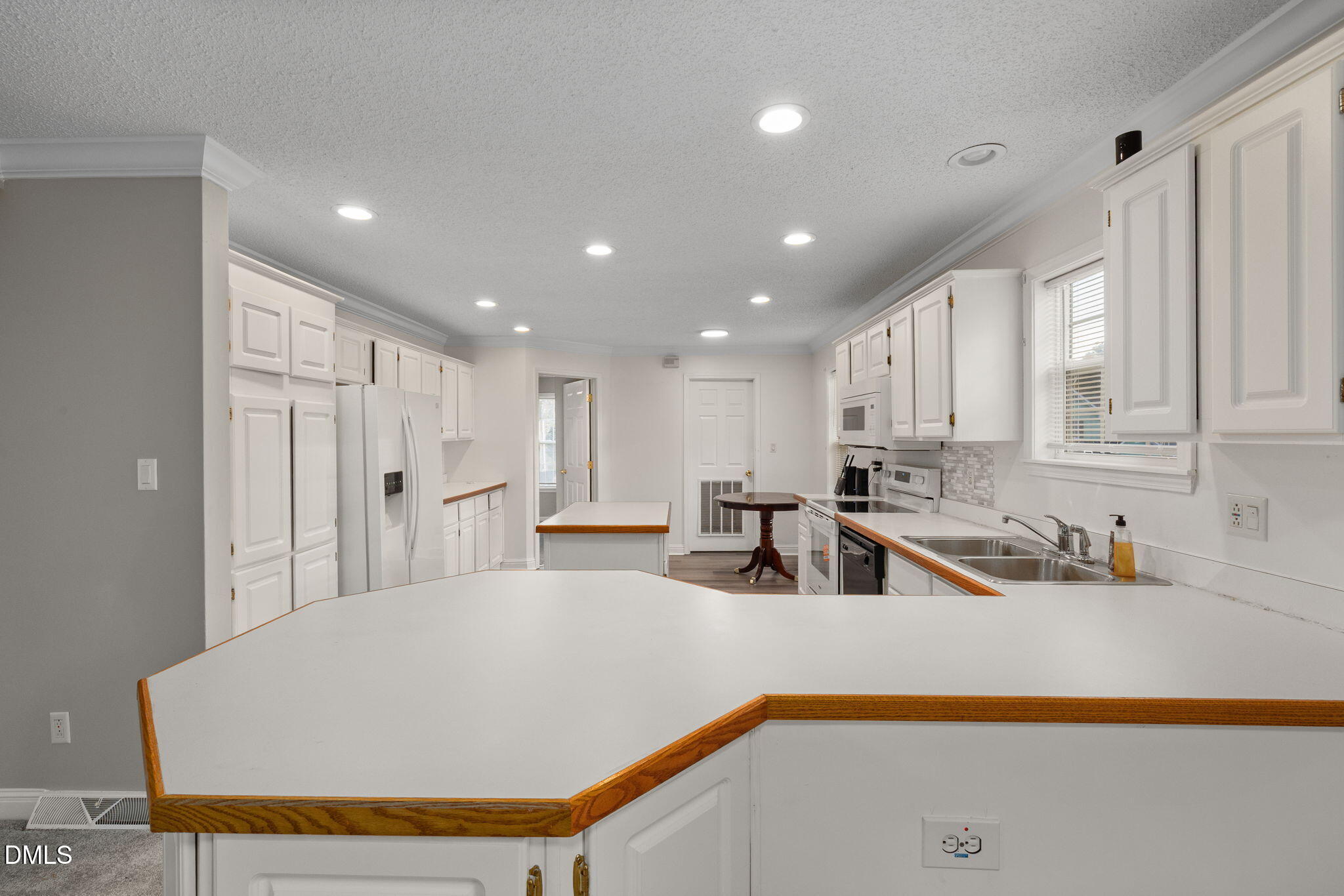 2850 Sanderford Road Raleigh, NC 27610 - Photo 15 of 34 a kitchen with stainless steel appliances a sink a refrigerator and white cabinets