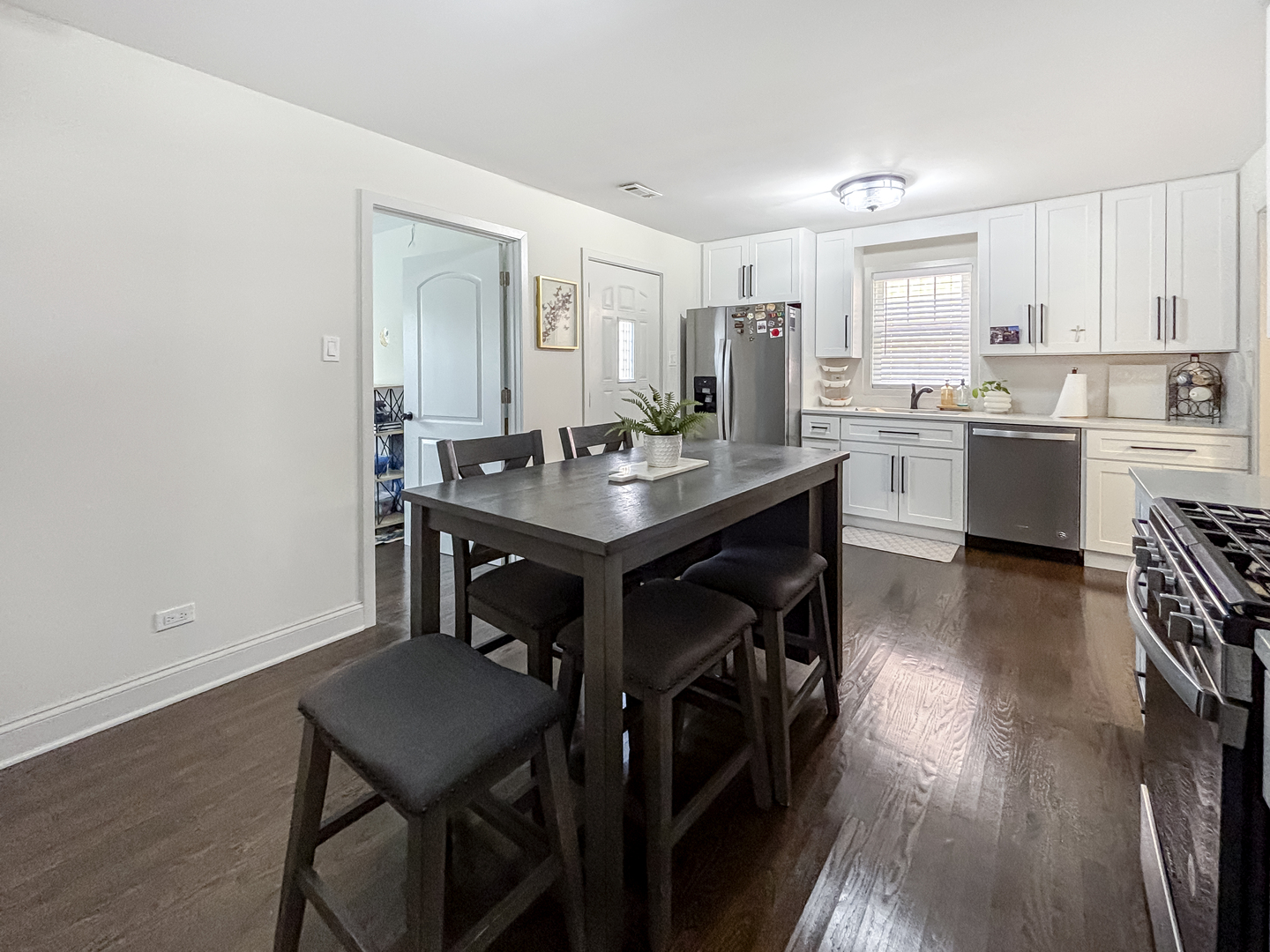 8538 45th Street Lyons, IL 60534 - Photo 13 of 29 a kitchen with a table chairs a sink dishwasher stove and cabinets with wooden floor
