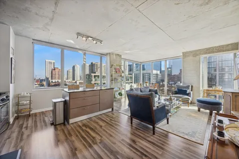 a living room with granite countertop furniture a kitchen view and wooden floor