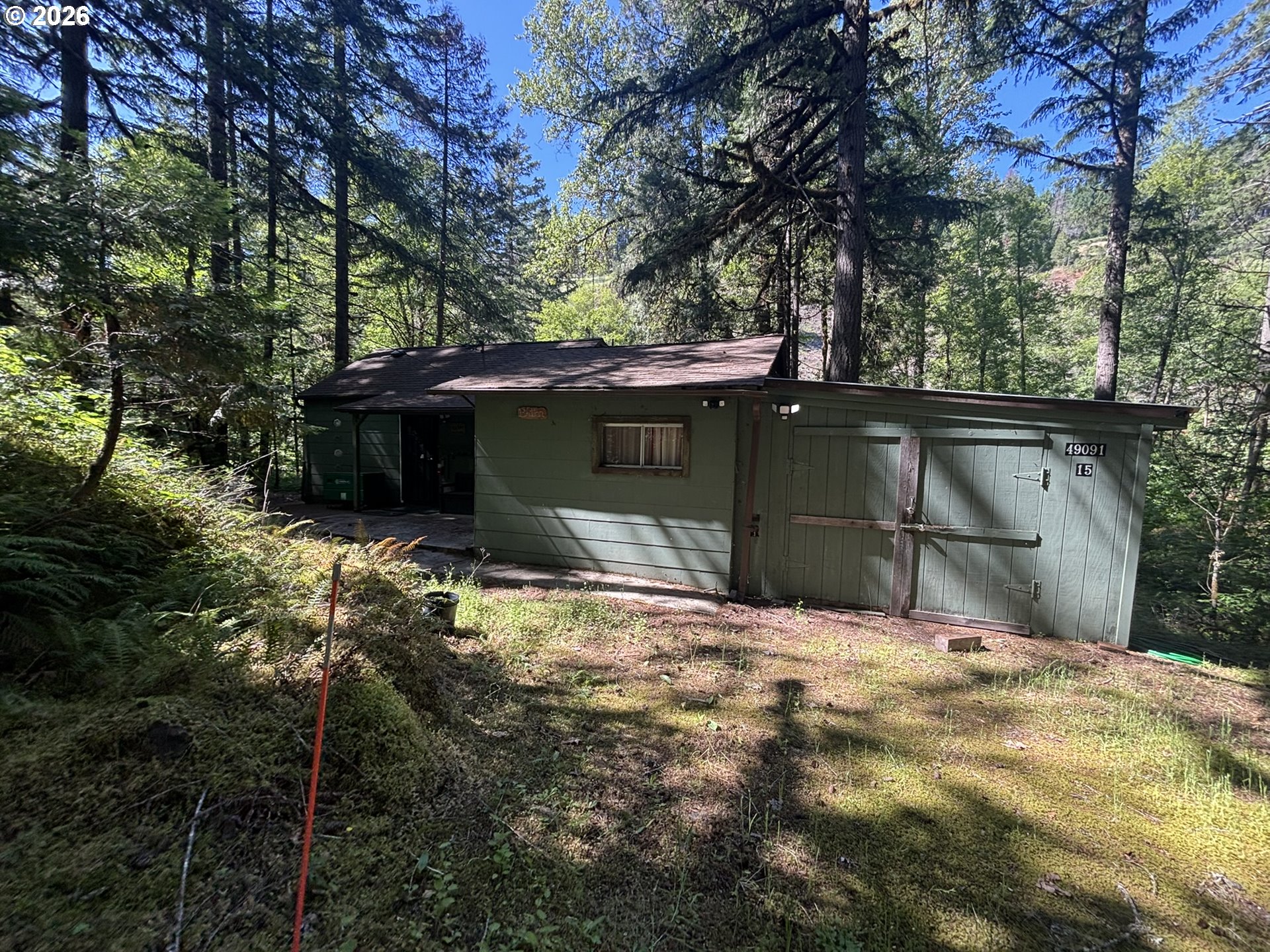 49091 Salt Creek Road Oakridge, OR 97463 - Photo 3 of 16 a backyard of a house with large trees and table and chairs