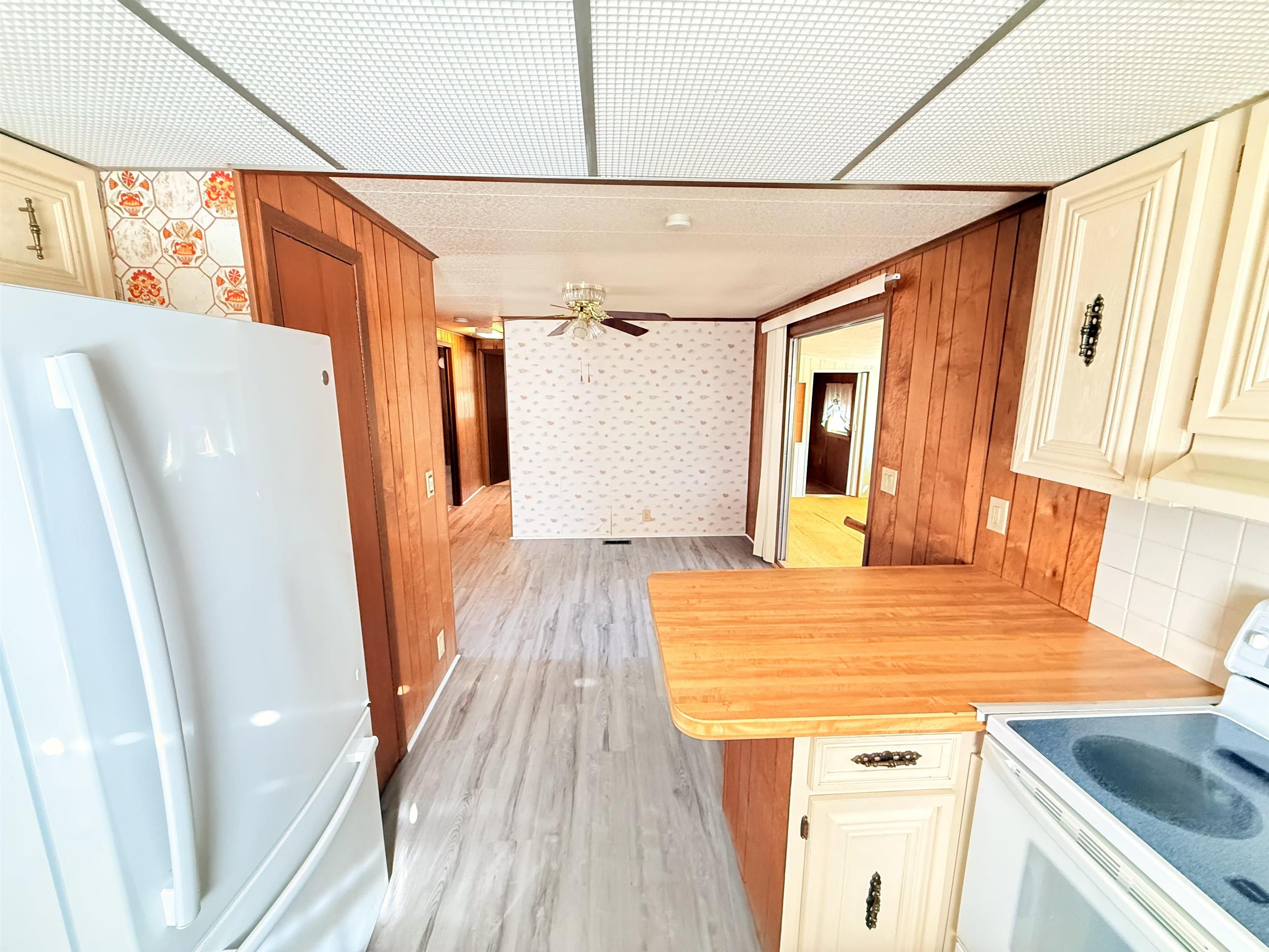 3043 Atlanta Circle Murrells Inlet, SC 29576 - Photo 11 of 36 Kitchen with white appliances, a peninsula, light countertops, light wood finished floors, and cream cabinetry