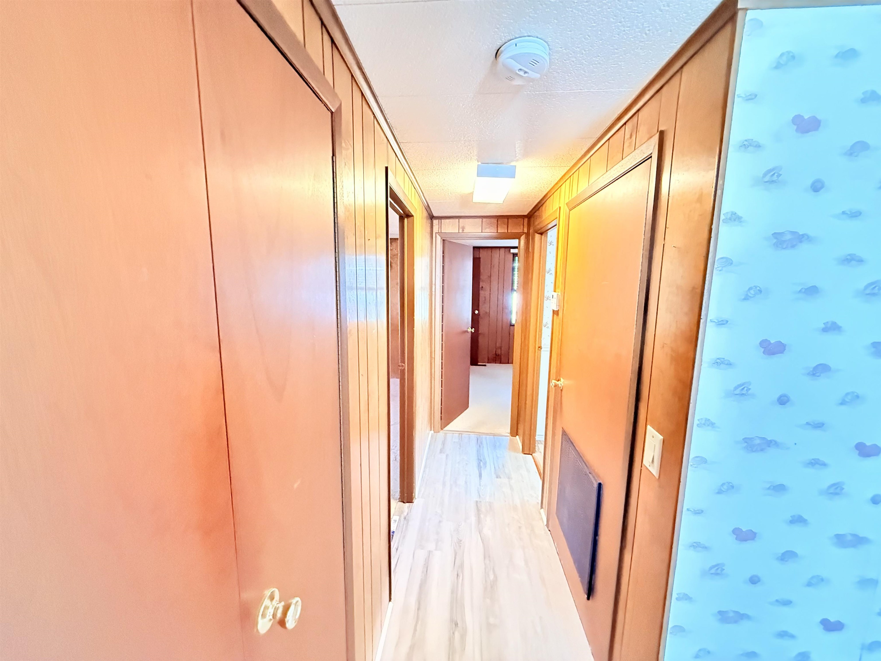 3043 Atlanta Circle Murrells Inlet, SC 29576 - Photo 12 of 36 Hallway with light wood finished floors, a textured ceiling, and wooden walls