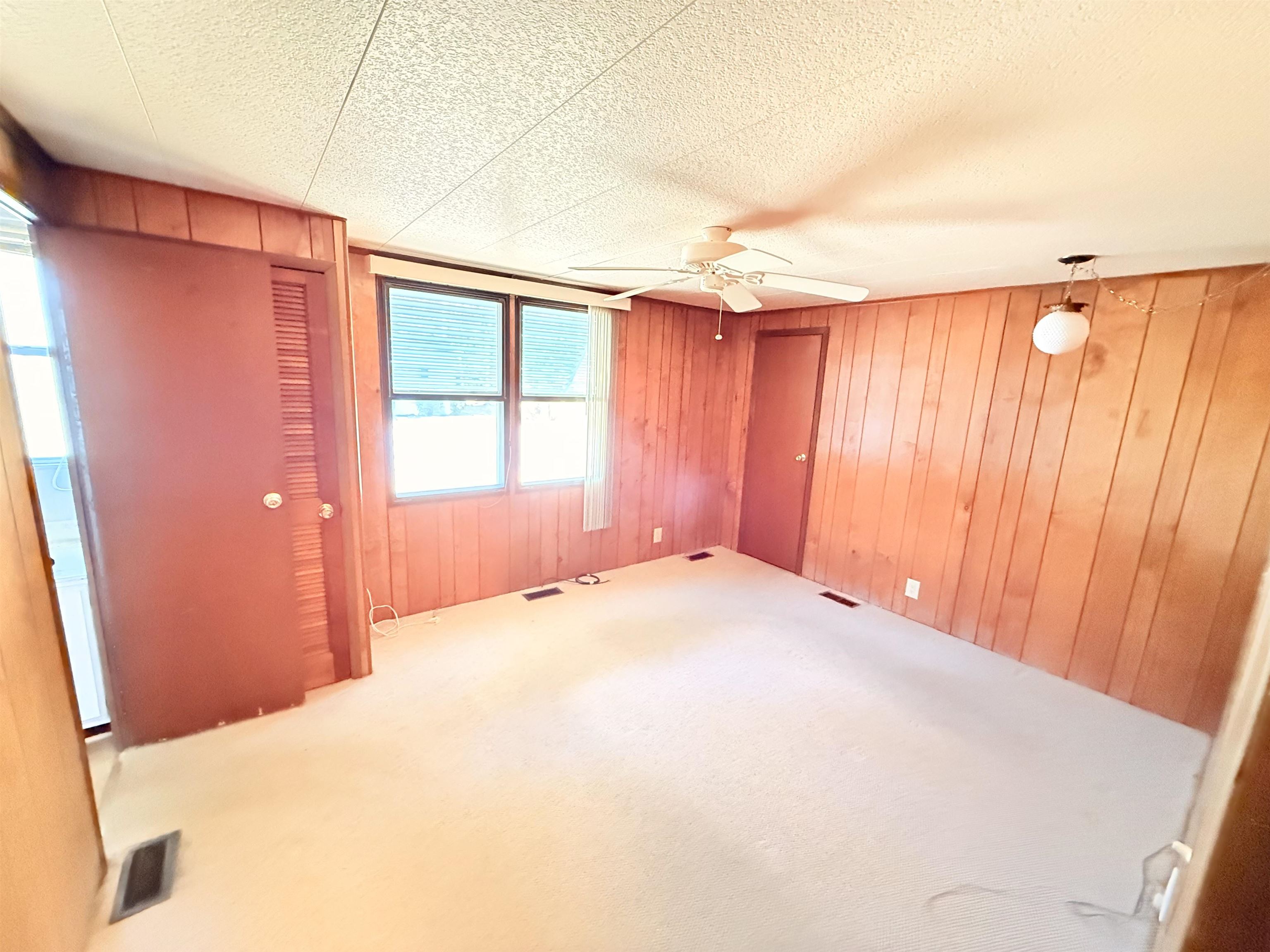 3043 Atlanta Circle Murrells Inlet, SC 29576 - Photo 13 of 36 Unfurnished bedroom featuring wooden walls, a closet, carpet floors, and ceiling fan