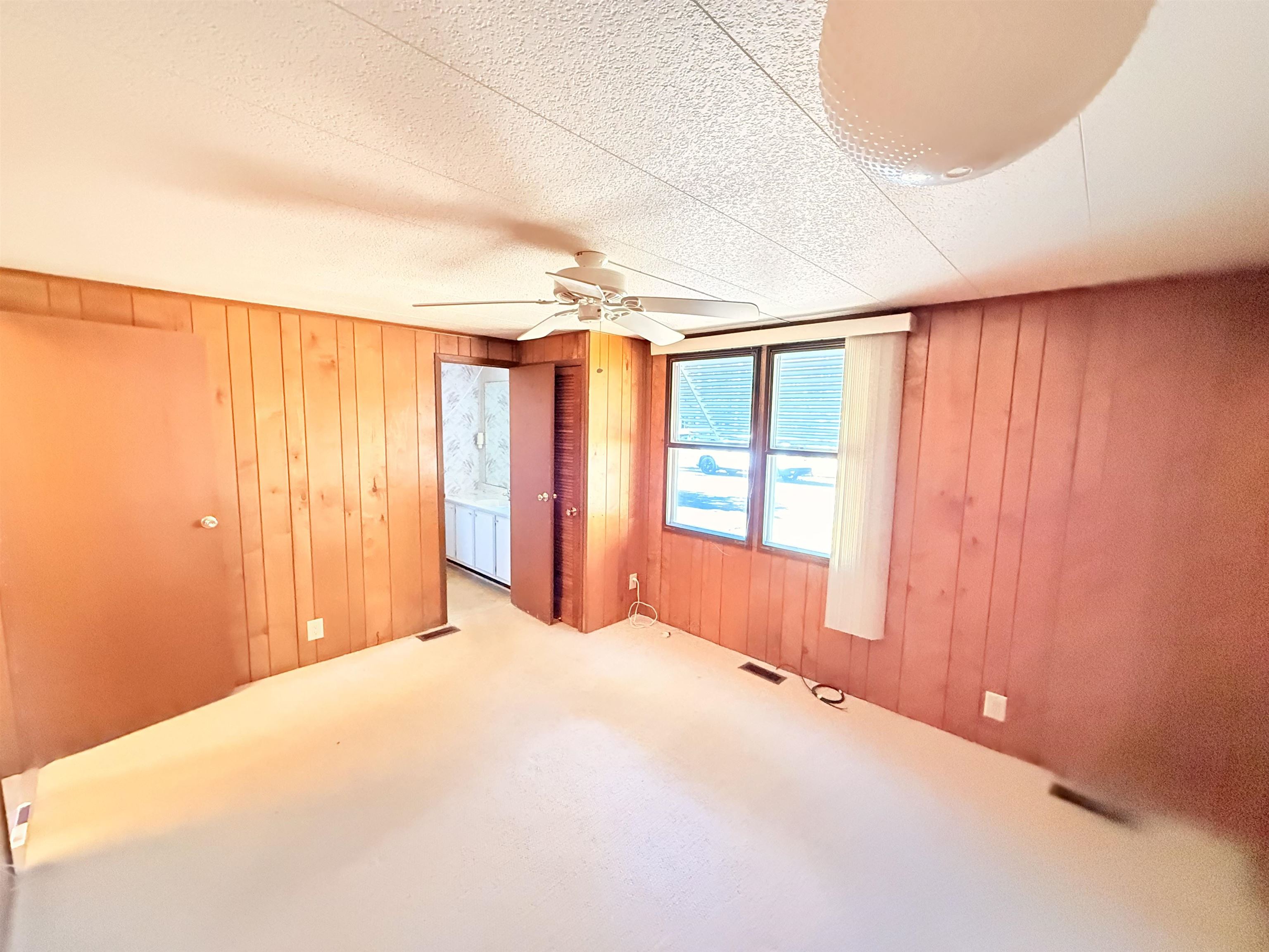3043 Atlanta Circle Murrells Inlet, SC 29576 - Photo 14 of 36 Unfurnished bedroom with wooden walls, carpet flooring, ceiling fan, and a textured ceiling