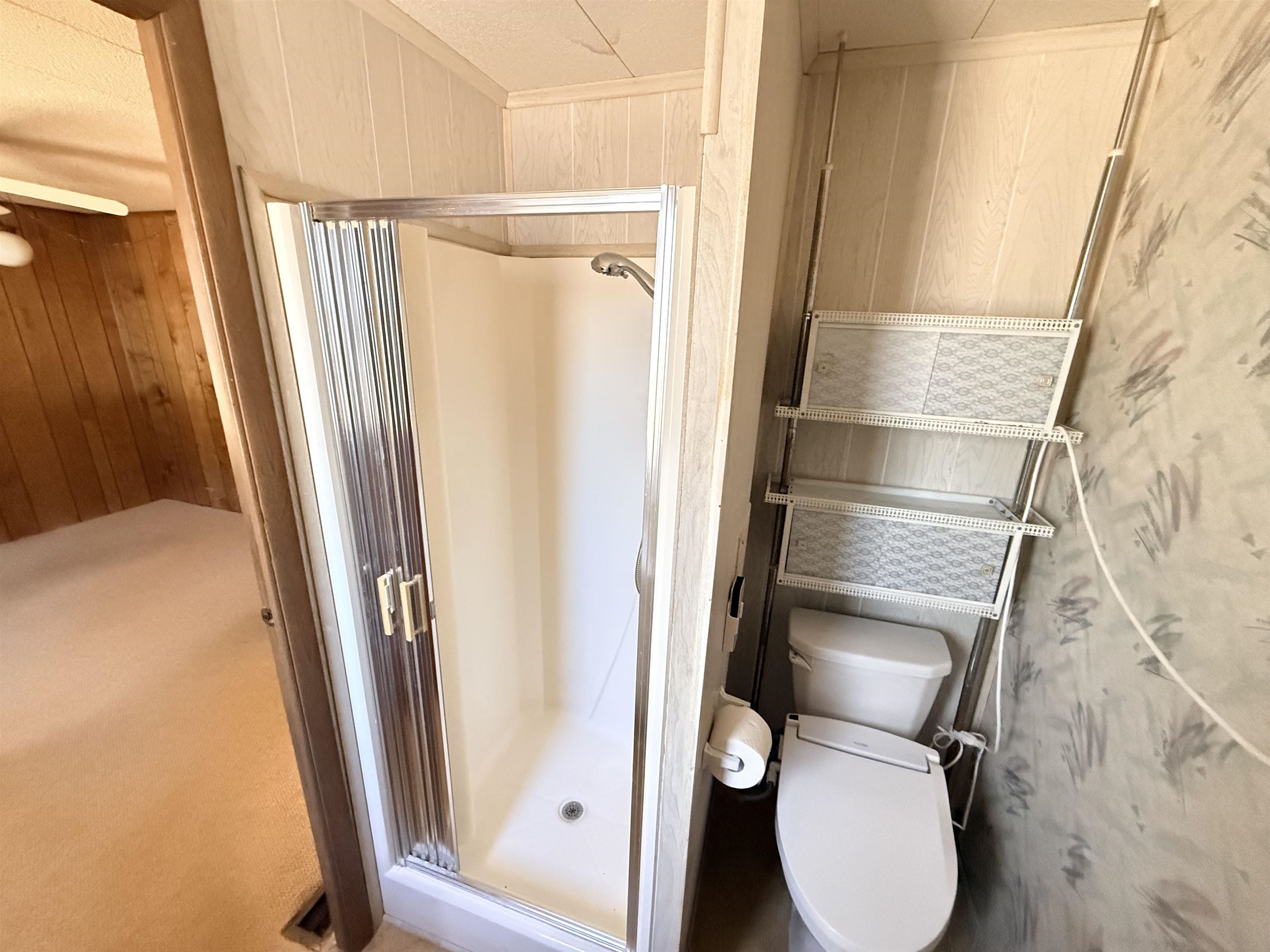 3043 Atlanta Circle Murrells Inlet, SC 29576 - Photo 16 of 36 Bathroom featuring wood walls, a stall shower, and light colored carpet