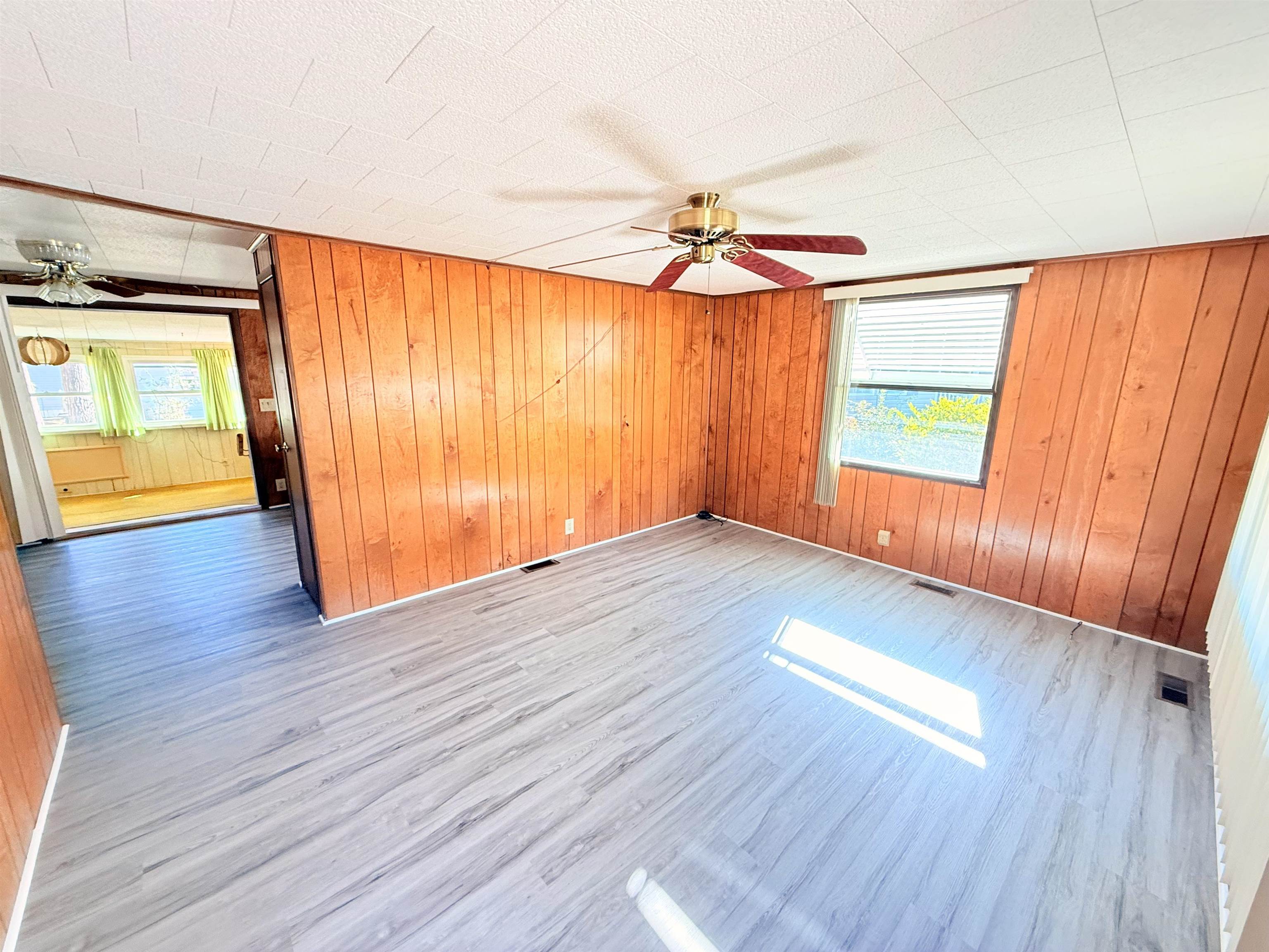 3043 Atlanta Circle Murrells Inlet, SC 29576 - Photo 5 of 36 Unfurnished room featuring ceiling fan, wooden walls, healthy amount of natural light, and wood finished floors