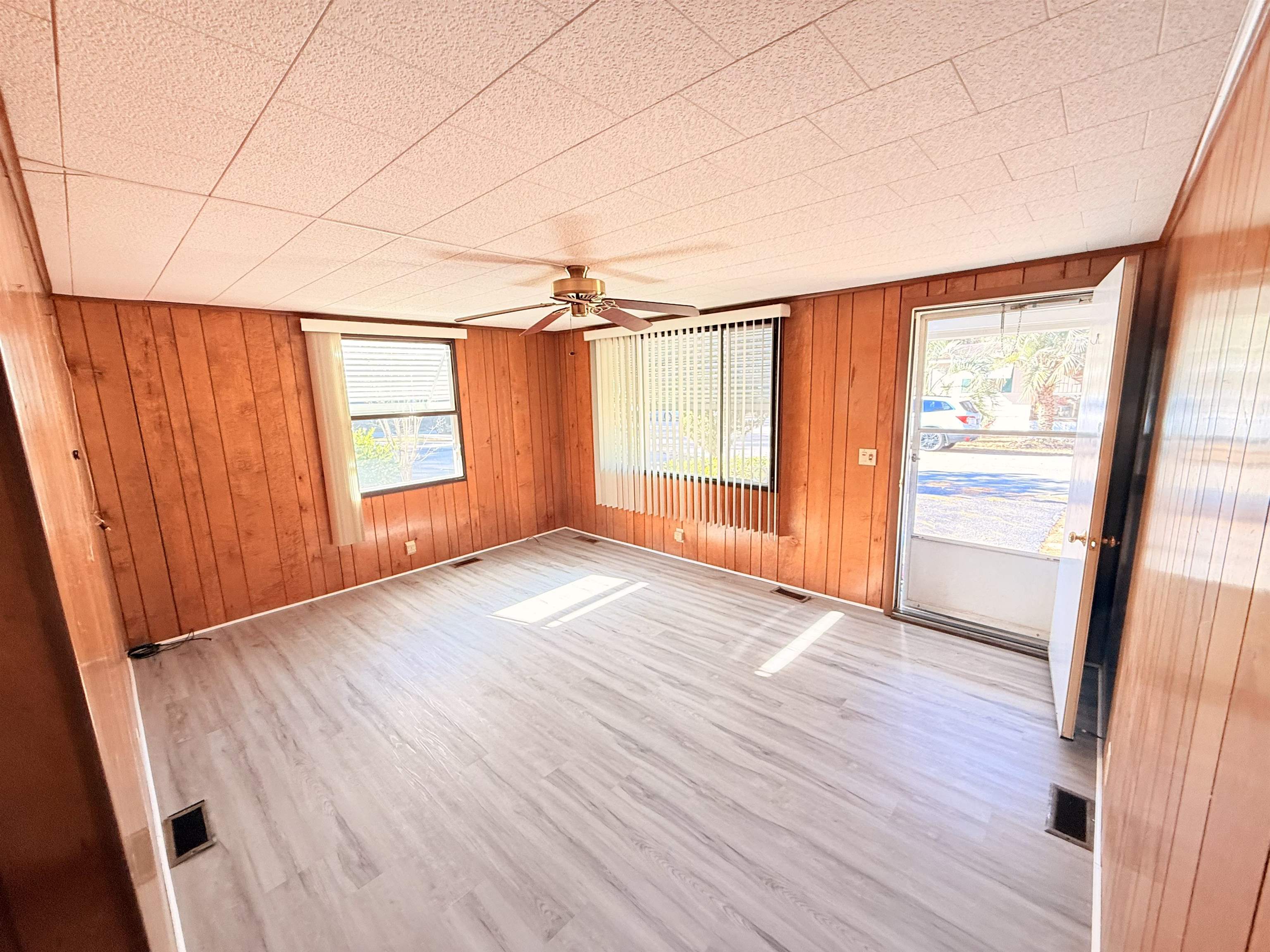 3043 Atlanta Circle Murrells Inlet, SC 29576 - Photo 6 of 36 Empty room with wood walls, a ceiling fan, and wood finished floors