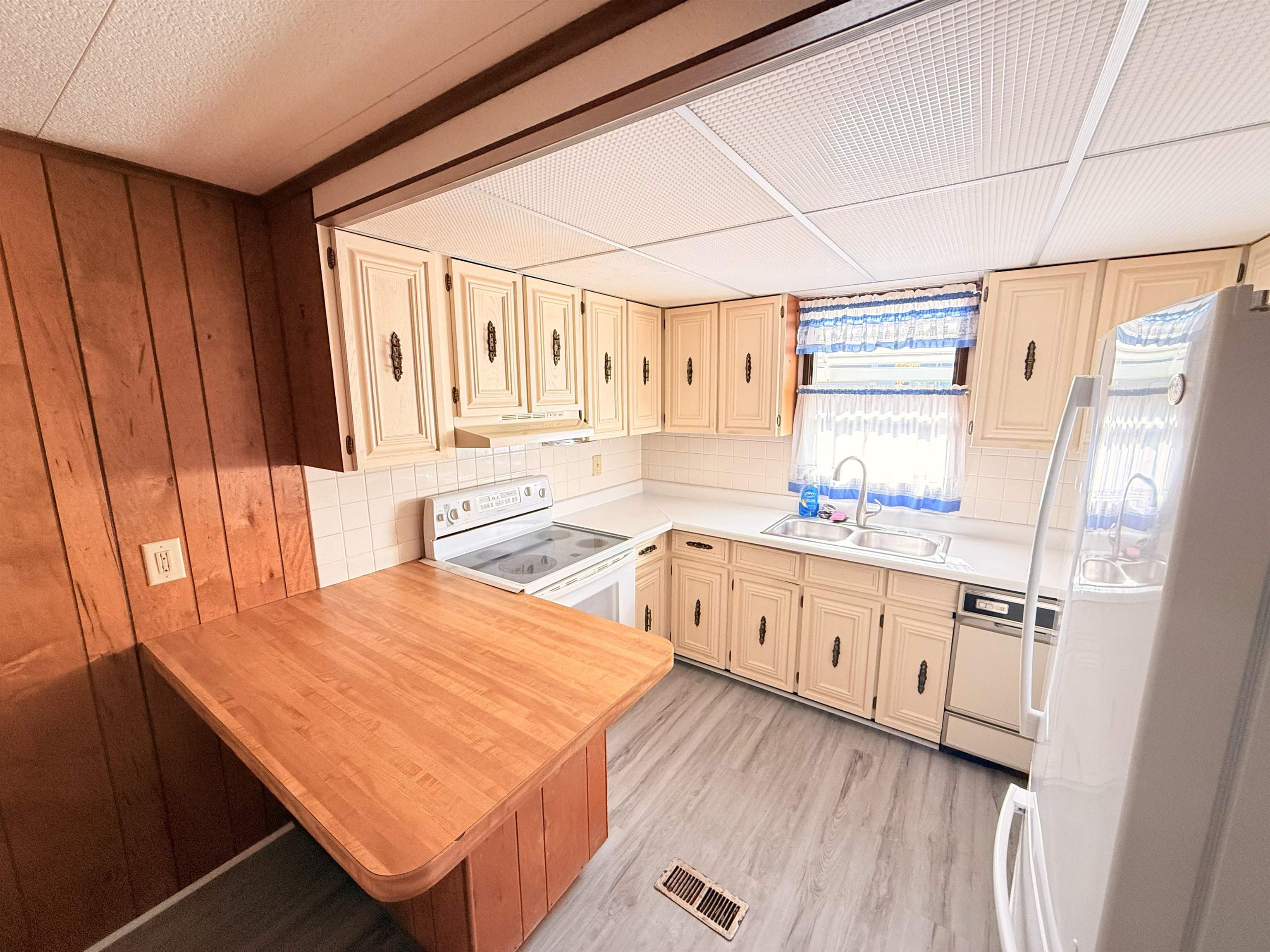 3043 Atlanta Circle Murrells Inlet, SC 29576 - Photo 10 of 36 Kitchen featuring white appliances, a peninsula, light countertops, a kitchen bar, and decorative backsplash