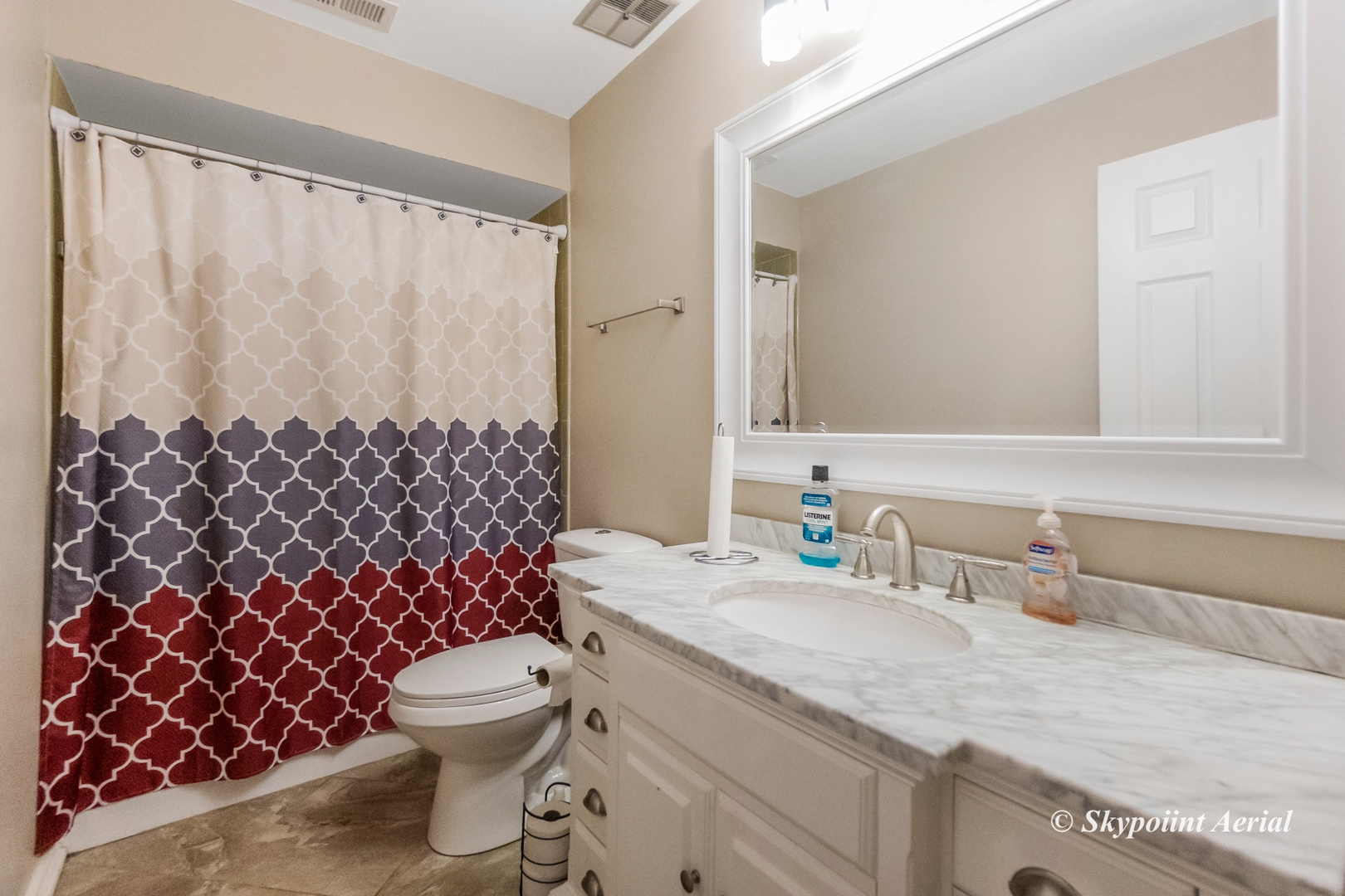 3231 West 184th Street, Unit 2B Homewood, IL 60430 - Photo 12 of 22 a bathroom with a granite countertop toilet a sink a mirror and a shower curtain