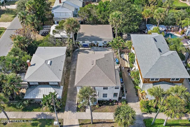 an aerial view of multiple houses with a yard