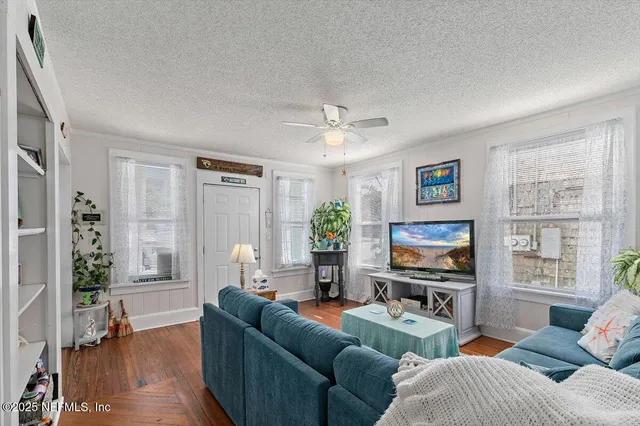 a living room with furniture a flat screen tv and a window