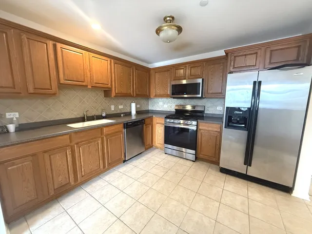 a kitchen with stainless steel appliances granite countertop a refrigerator sink and cabinets