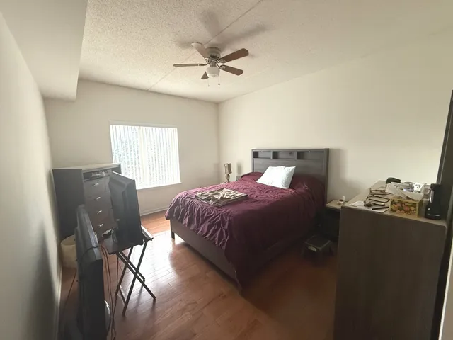 a bedroom with a bed and dresser with mirror