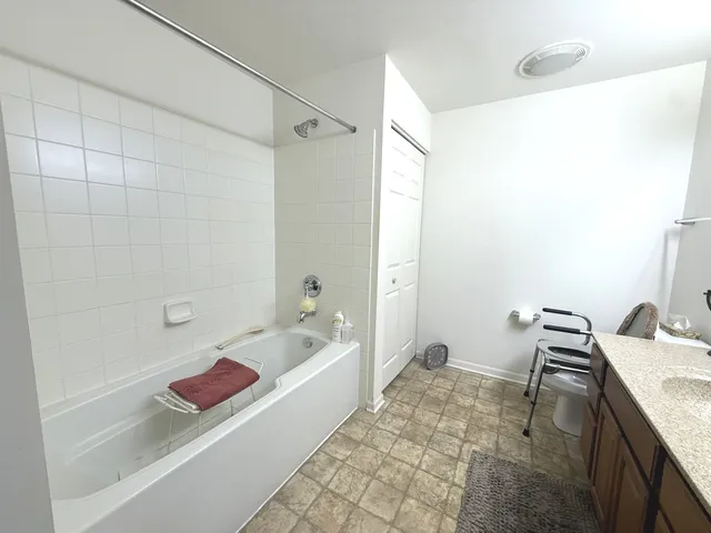 a bathroom with a granite countertop sink a toilet and shower