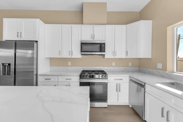 a kitchen with cabinets stainless steel appliances and a counter space