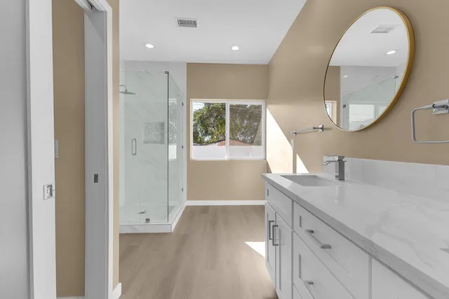 a bathroom with a granite countertop sink toilet and shower