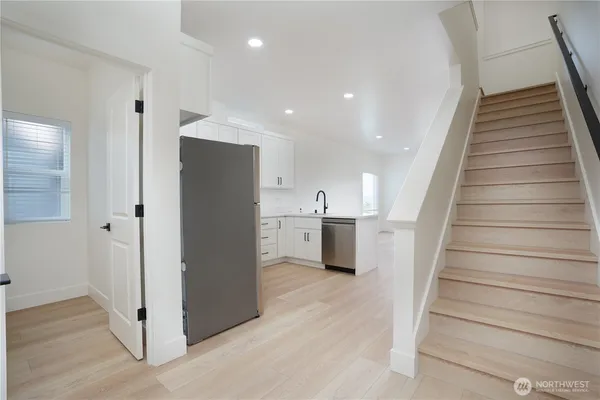 a view of a kitchen with wooden floor and electronic appliances