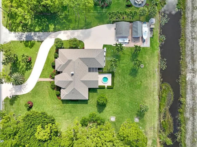 an aerial view of a house with a yard and lake view