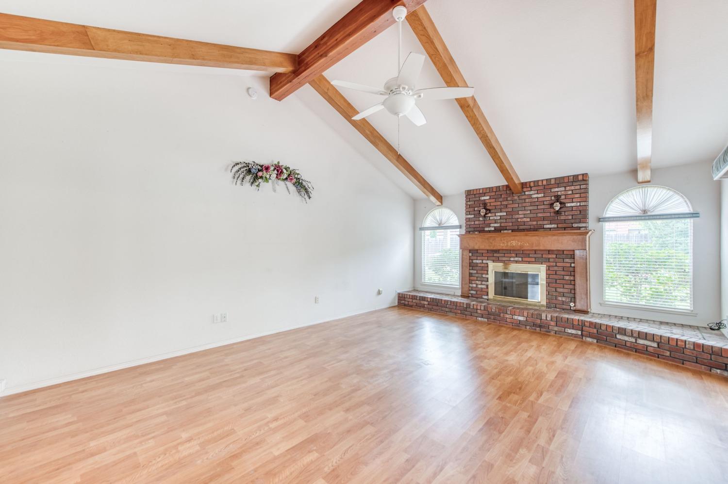 2530 Sterling Avenue Sanger, CA 93657 - Photo 18 of 40 an empty room with wooden floor fireplace and windows